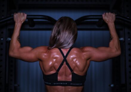 femme en train de travailler ses muscles du dos en salle de musculation