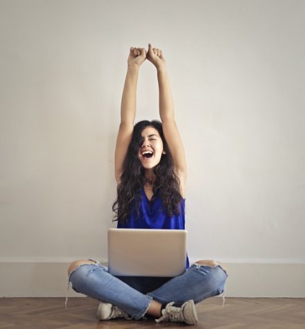 femme qui s'étire avec un ordinateur sur les genoux