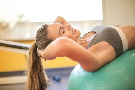 femme en train de faire du sport sur un ballon fitness