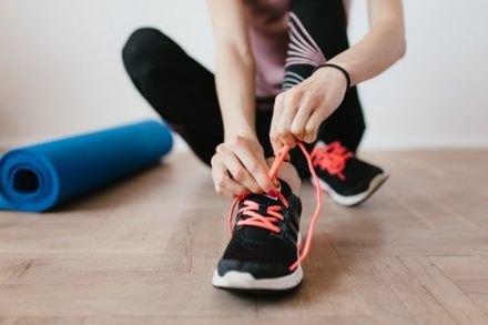 sportive en train de lacer ses chaussures de sport en salle