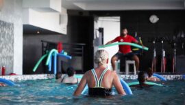 femme de dos dans une piscine en cours d'aquagym