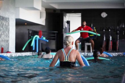 femme de dos dans une piscine en cours d'aquagym