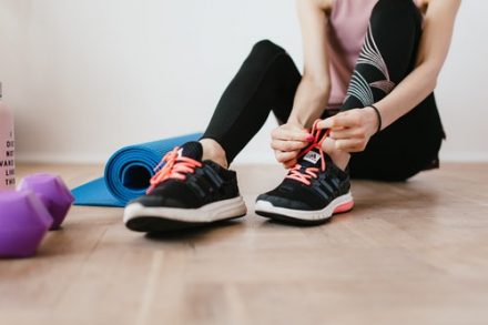 femme en train de lacer ses baskets de sport