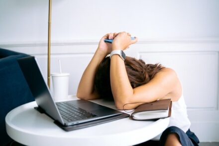 femme fatiguée qui s'appuie sur son ordinateur