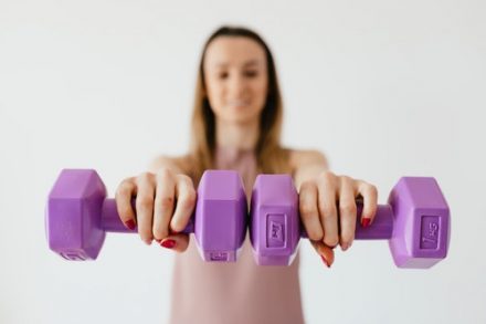 femme portant des haltères dans chaque main