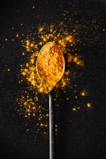 cuillère à café remplie de poudre de curcuma