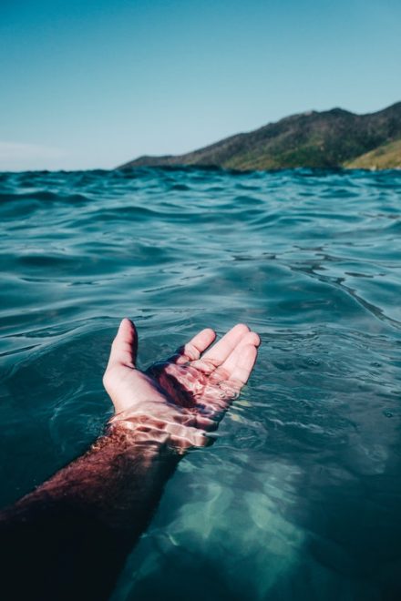 main qui sort de l'eau de mer