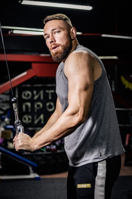 homme à moustache et barbe faisant de la musculation