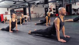 homme et femme en posture d'étirement dans une salle de sport