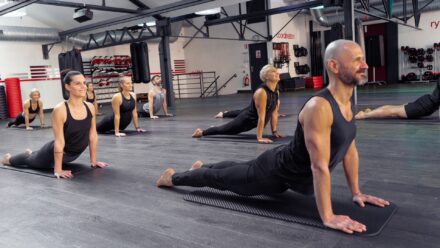 homme et femme en posture d'étirement dans une salle de sport