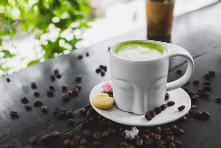 tasse de thé matcha et grains de café sur une table