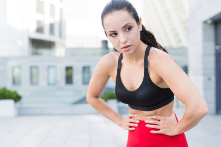 femme en tenue de sport se tenant le ventre