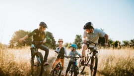 Des parents et leurs enfants font du vélo dans les champs en pleine campagne