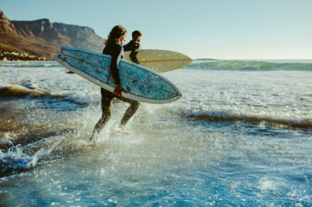 deux surfeurs se dirigeant vers les vagues