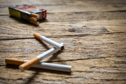 3 cigarettes et un paquet de cigarettes posés sur une table