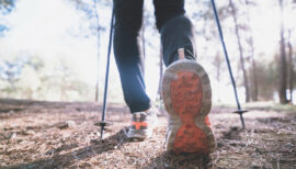 les pieds d'une personne pratiquant la marche nordique avec bâtons