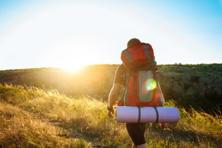 homme faisant de la randonnée en été au coucher du soleil
