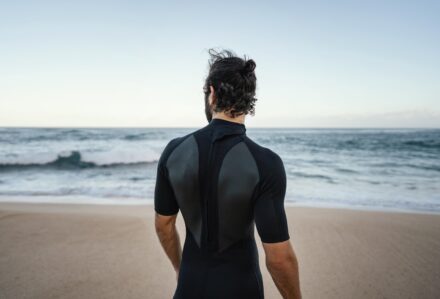 homme en shorty en bord de mer avant sa session de longe côte