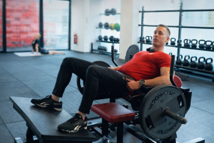 coach sportif WellNess faisant un hip thrust sur machine