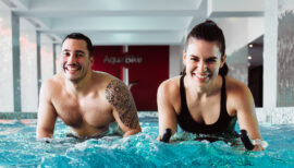 un couple pratiquant l'aquabike en salle de sport
