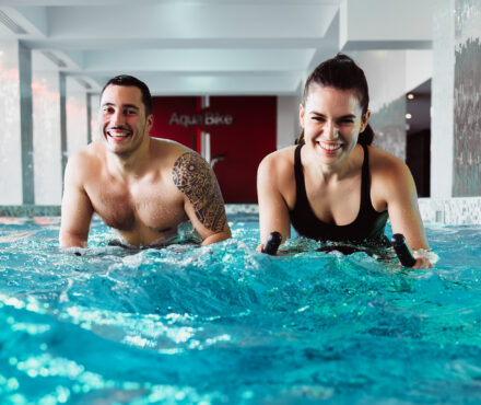 un couple pratiquant l'aquabike en salle de sport