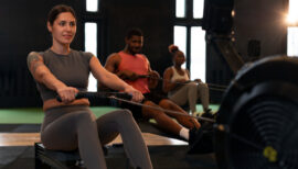 personnes faisant du rameur en salle de sport