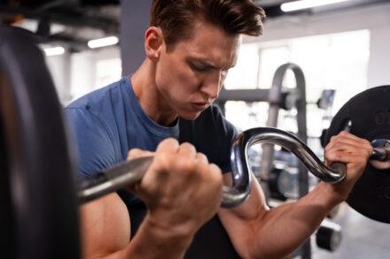 homme soulevant un poids en salle de sport